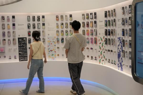 A couple looks as smartphone case designs on display at The Hyundai Seoul's Casetify in Yeongdeungpo-gu, Seoul, Tuesday. (Lee Si-jin/The Korea Herald)