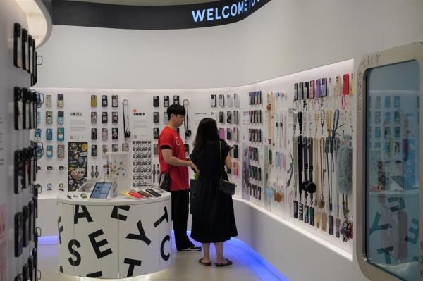 An assistant shows a visitor different designs at The Hyundai Seoul's Casetify on Tuesday. (Lee Si-jin/The Korea Herald)