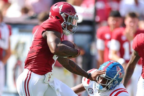 TUSCALOOSA, ALABAMA - SEPTEMBER 23:  Jalen Milroe #4 of the Alabama Crimson Tide rushes and stiff arms Trey Washington #25 of the Mississippi Rebels during the first quarter at Bryant-Denny Stadium on September 23, 2023 in Tuscaloosa, Alabama. (Photo by Kevin C. Cox/Getty Images)